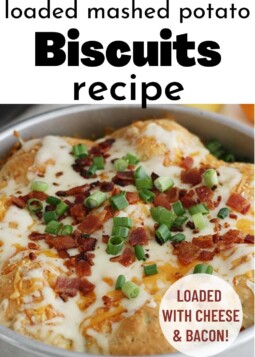 Round pan of biscuits topped with melted cheese, bacon bits, and green onion with text stating loaded with cheese and bacon.