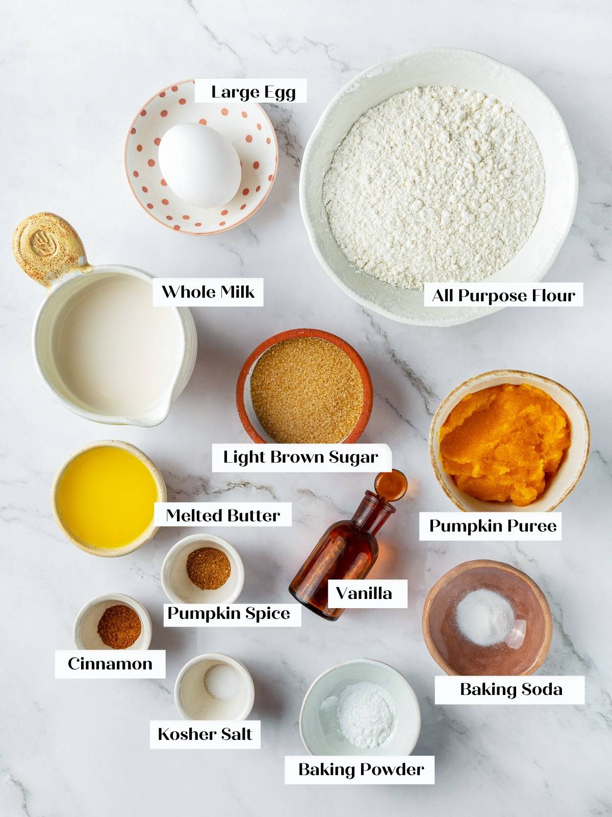 Measured flour, sugar, pumpkin puree, and spices laid out for making fluffy pumpkin pancakes.