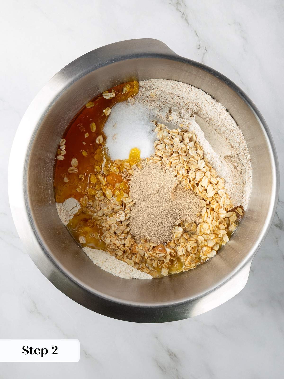 Ingredients in bowl, including flour, oats, yeast, and seeds before mixing.