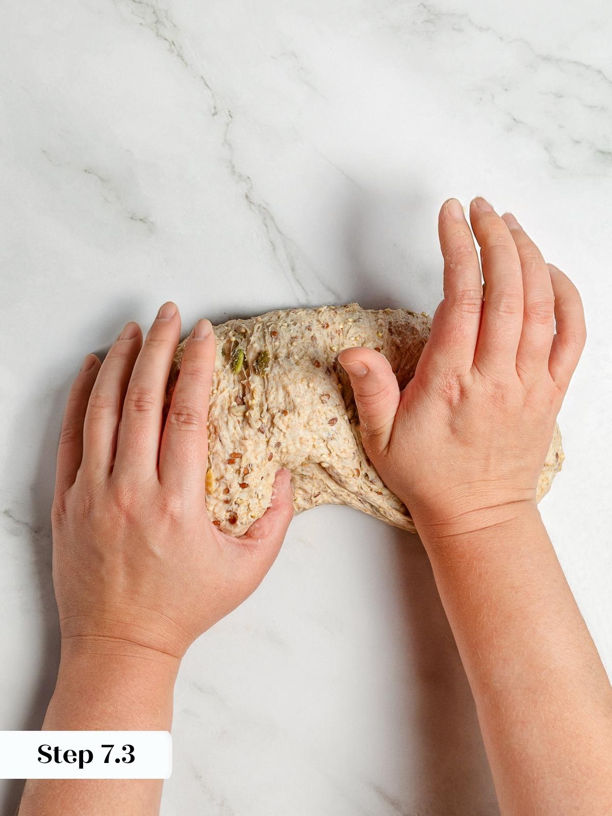 Baker&rsquo;s hand sealing dough bottom to tighten loaf shape before proofing.