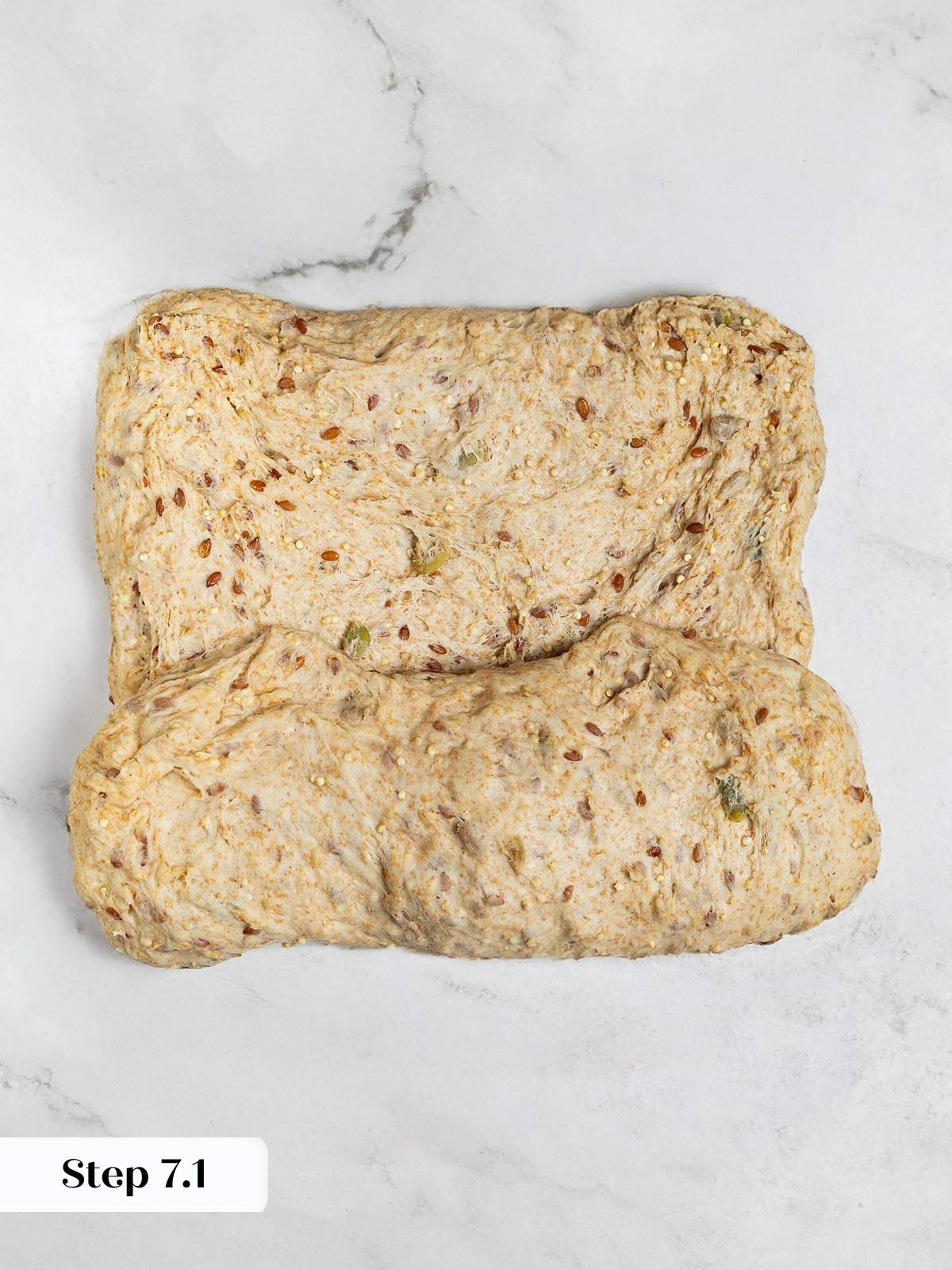 Shaping whole grain dough into rectangular loaf for seeded bread baking.