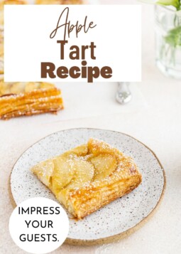 A rustic apple tart slice on a plate, with browned sugar edges and flaky crust.