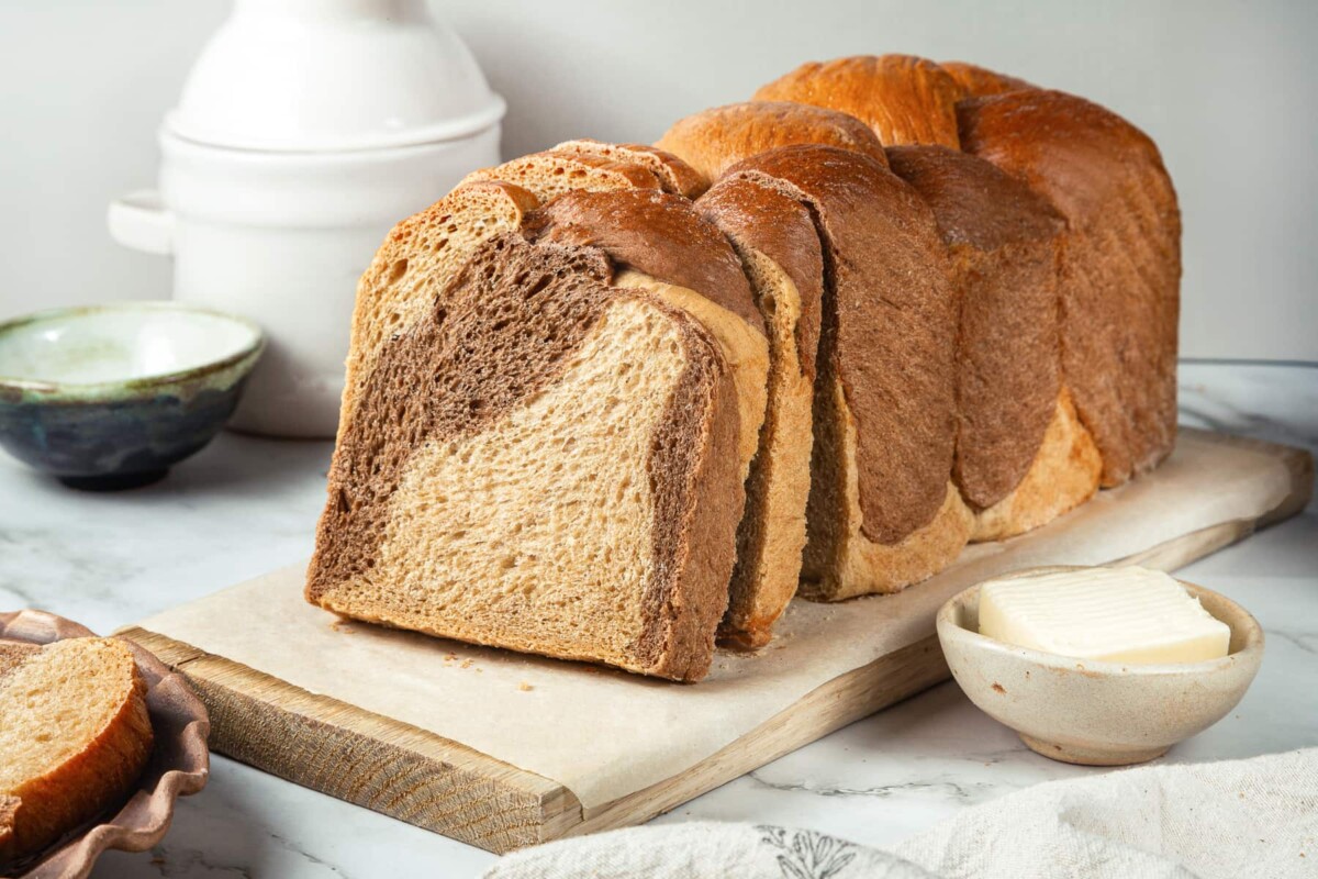Finished marble rye bread loaf resting on counter, highlighting marbled top pattern.