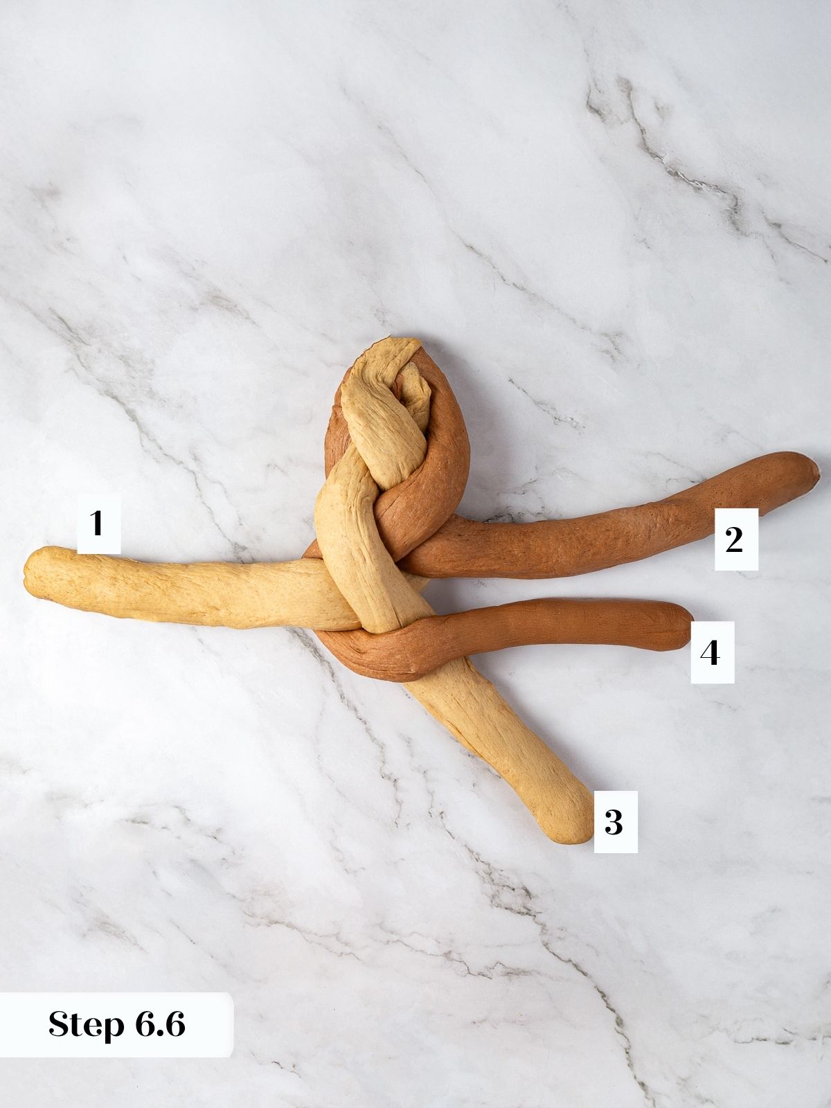 Rye dough strands being crossed to form the signature marbled braid pattern.