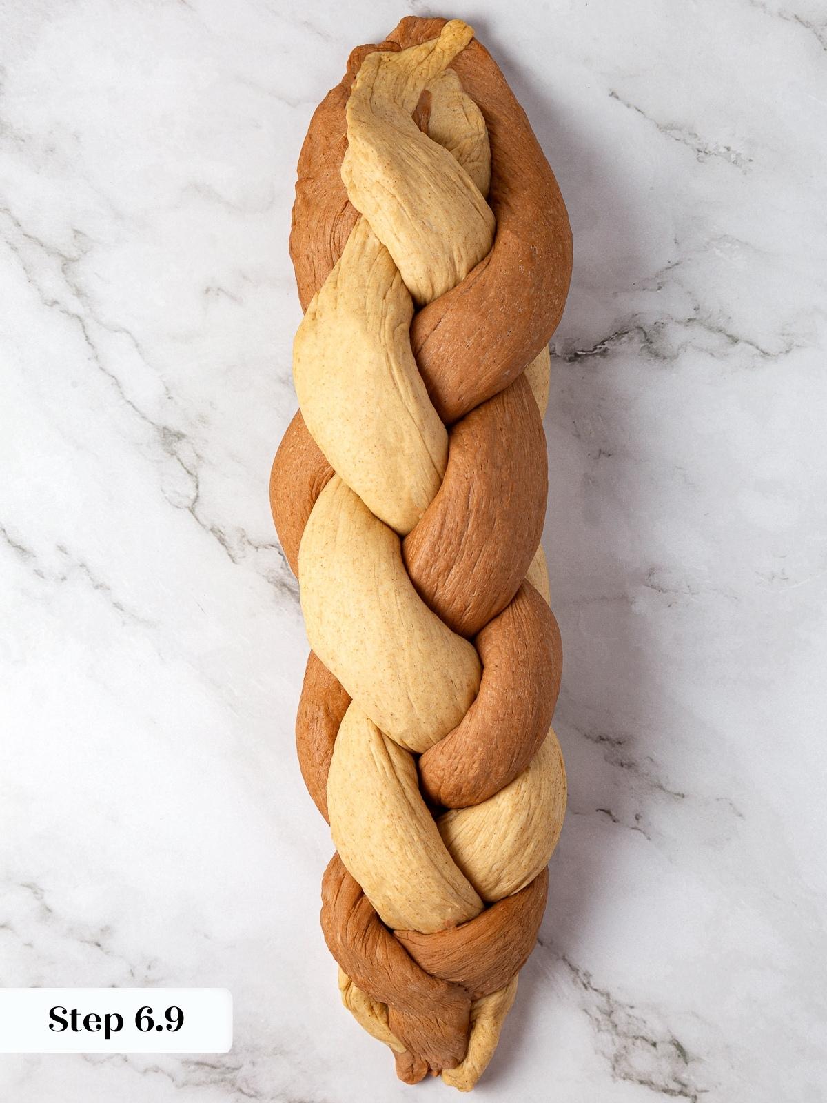 end of braiding marble rye dough, creating a balanced marbled pattern.