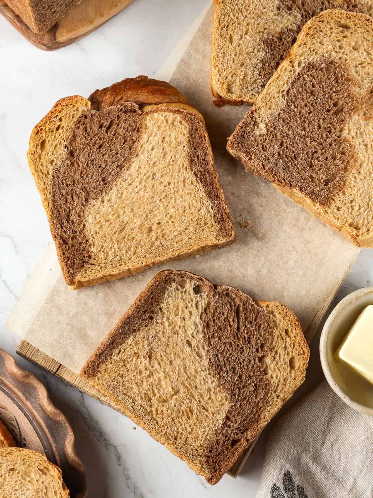 Golden braided rye bread resting on a wood board ready for serving.
