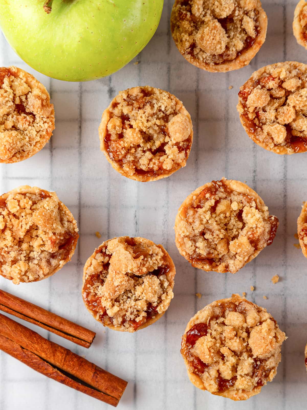 Fully baked mini apple pies cooling after being removed from the oven.