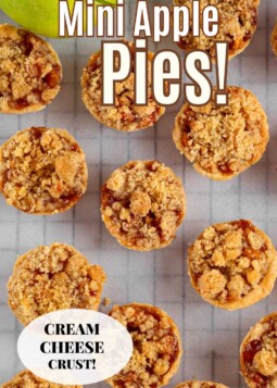 Holiday dessert table featuring small apple pies with brown sugar topping and tender flaky crusts.