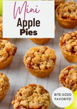 Bite-sized apple pies with tangy cream cheese crust and buttery crumble cooling on a baking rack.