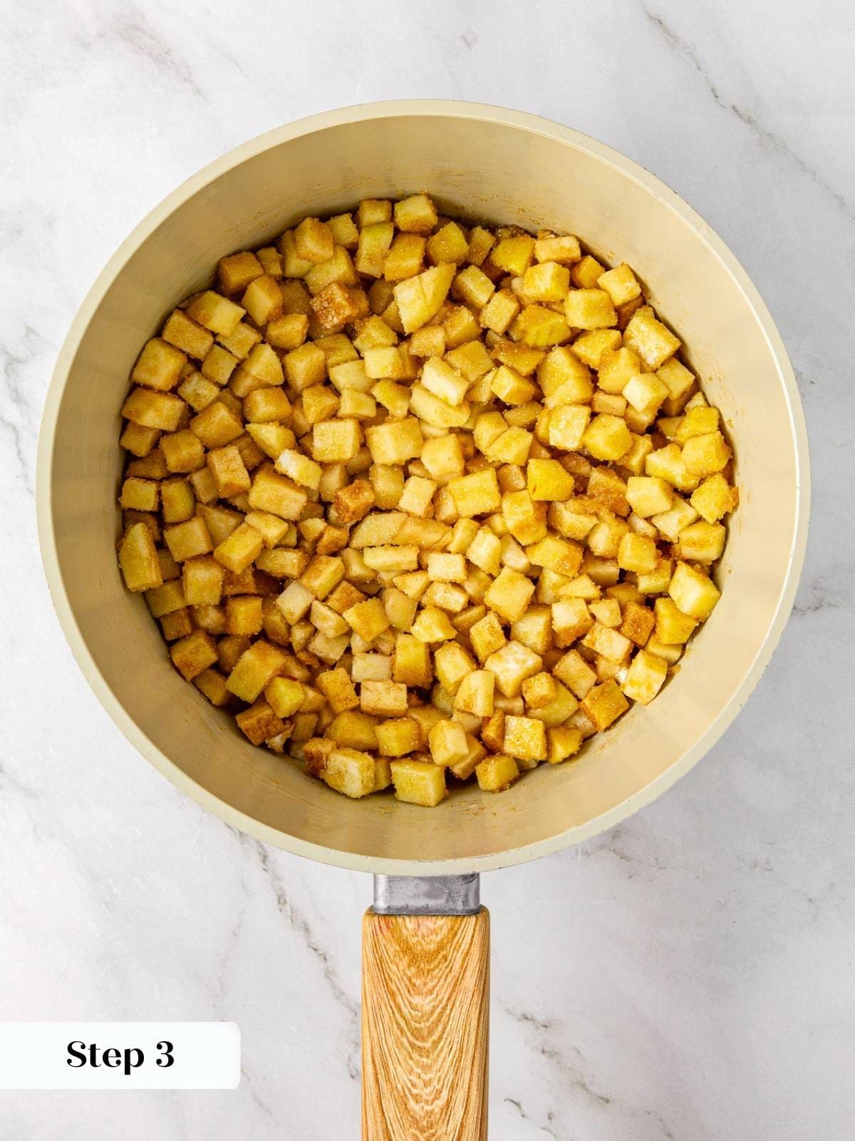 Apples simmering with sugar and cinnamon inside a pot for pie filling.