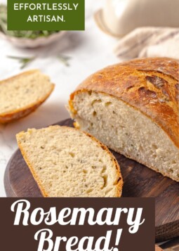 Sliced rosemary bread revealing soft, airy texture inside a perfectly browned homemade loaf.