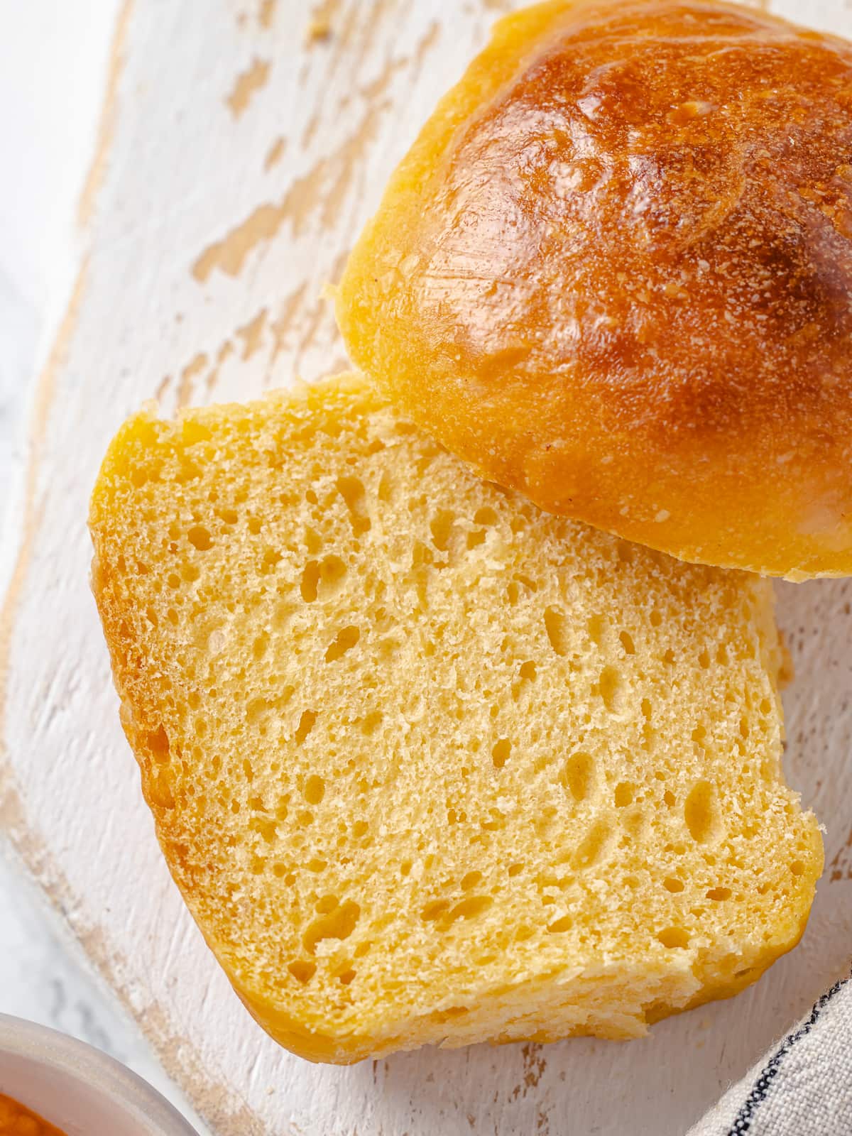 Sweet potato roll pulled apart to show its soft, fluffy crumb and rich color.