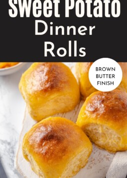 Warm, fluffy sweet potato rolls resting on a kitchen counter.