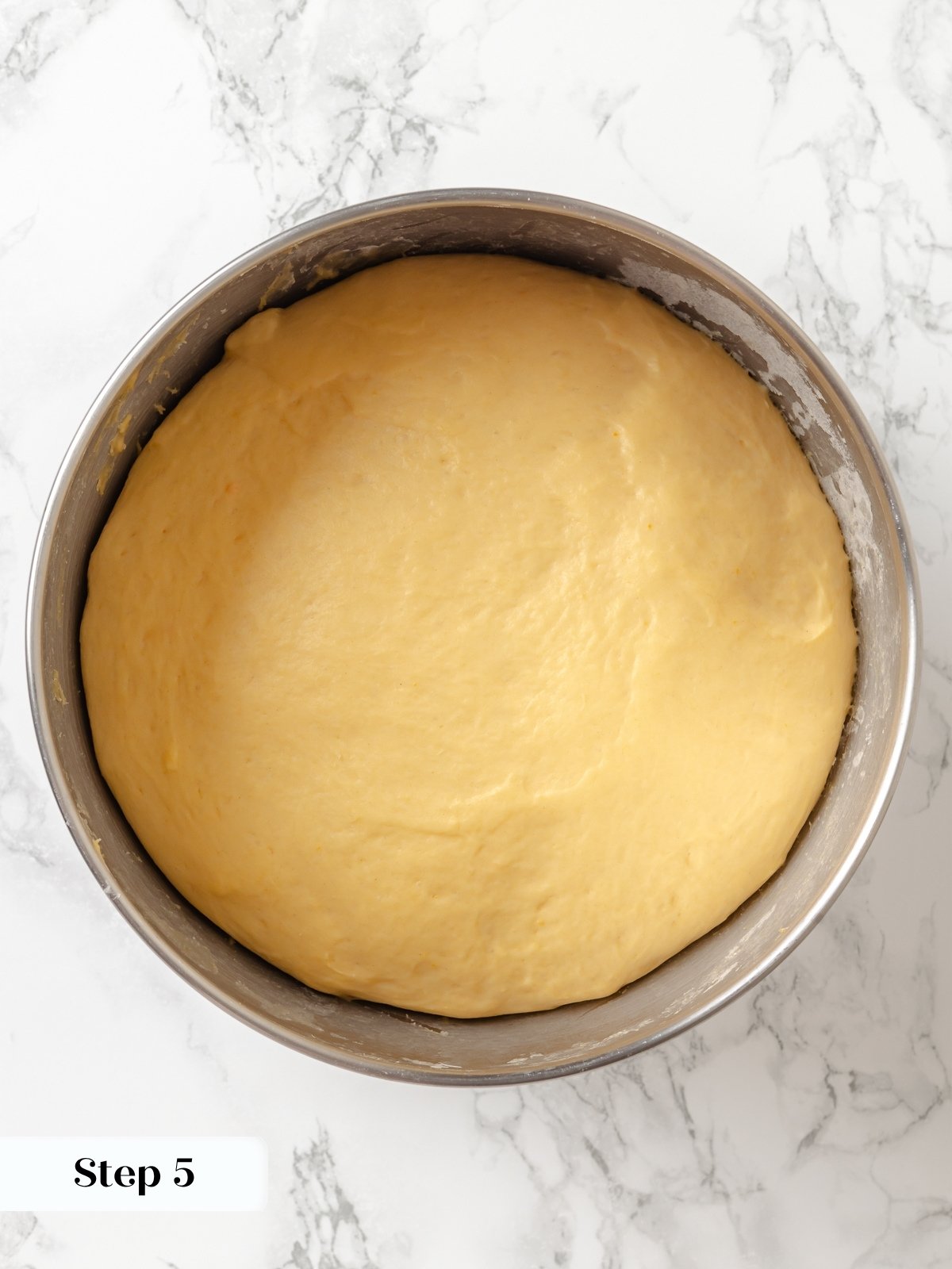 Proofed sweet potato dough showing soft, smooth texture ready for shaping into rolls.