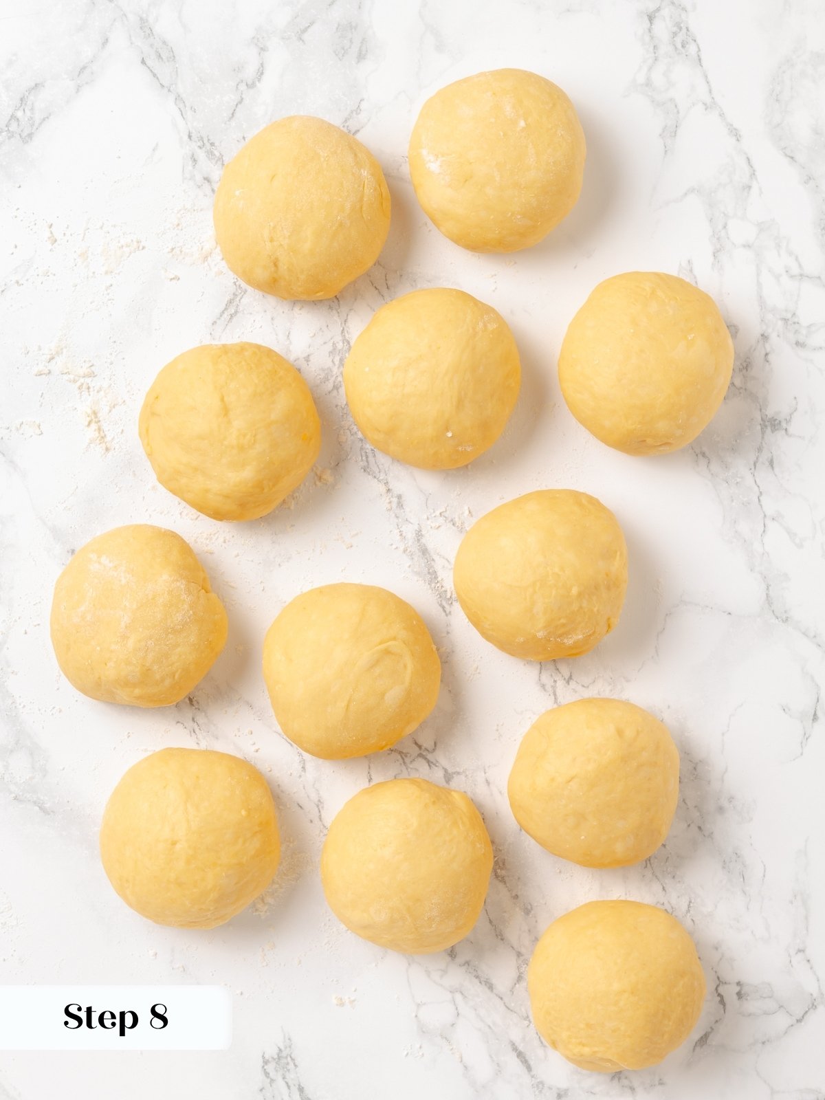 Rolled portions of sweet potato dough shaped into boules and placed on a floured surface.