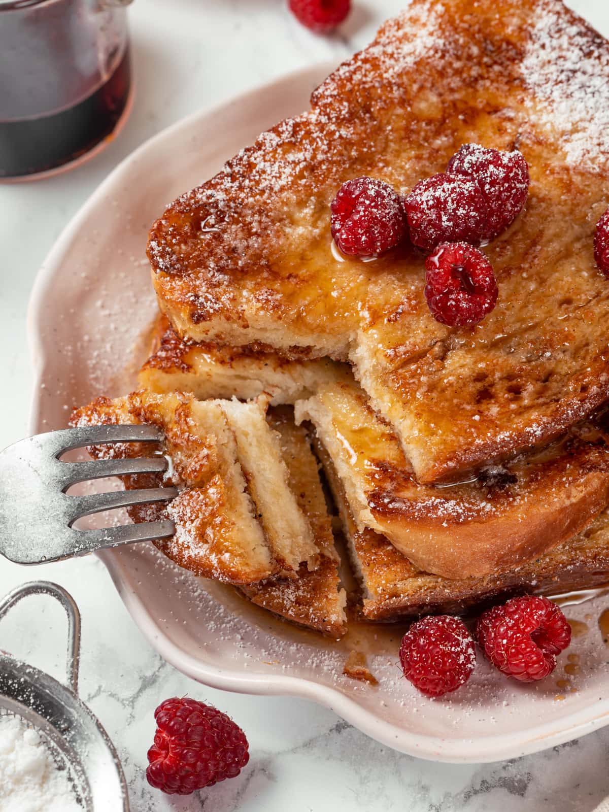 Piece of French toast sliced open to reveal a light, custardy center inside golden crust.