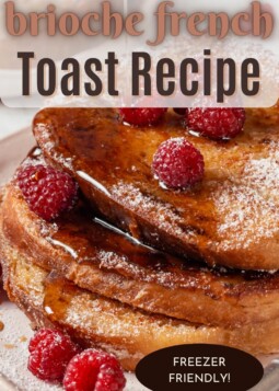 Slices of buttery French toast stacked high on a white plate with berries on top.