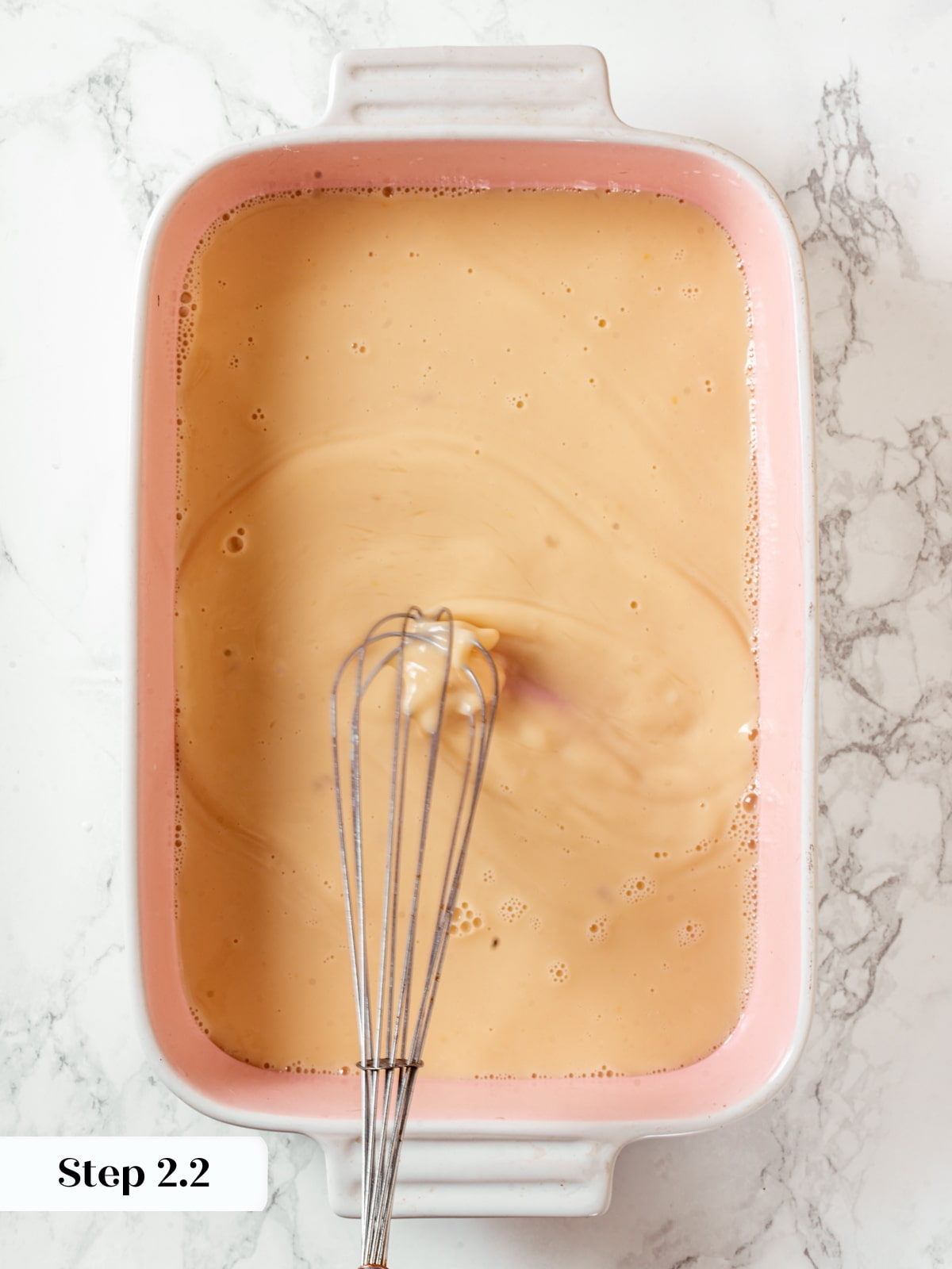 Custard mixture of eggs, milk, and maple syrup combined in a baking dish for soaking bread.