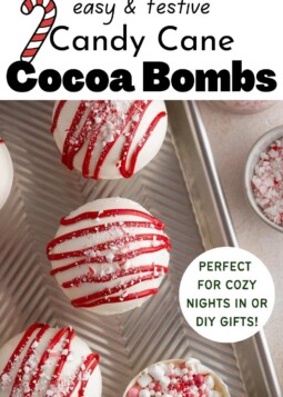 White candy cane cocoa bombs drizzled with red white chocolate and crushed candy canes.