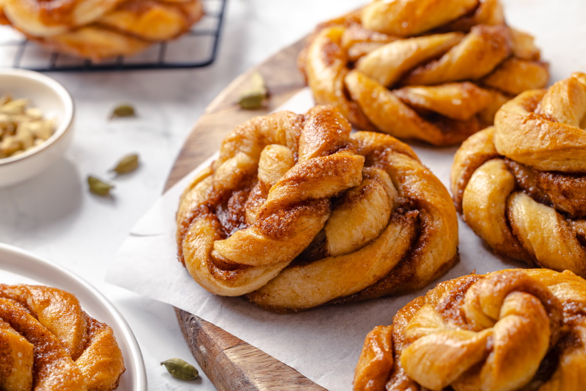 Buns resting on a cutting board showing their golden crust and twisted layers.