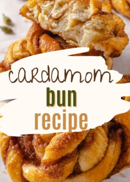 A single cardamom bun pulled apart to show soft layers and spiced filling inside.