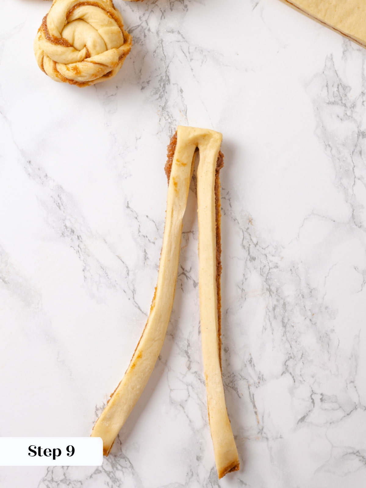 Preparing a dough strip by cutting a long slit for twisting into a bun.