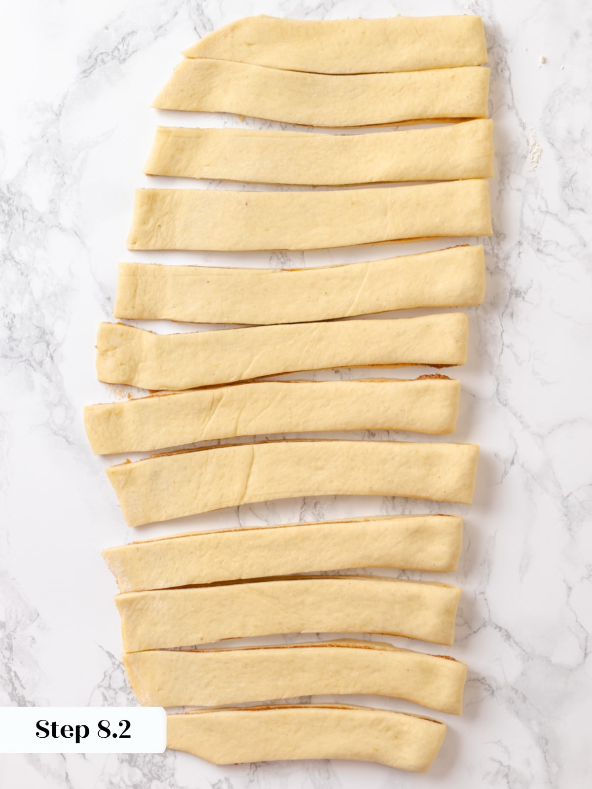 Dough divided into even sections using a bench scraper before rolling and cutting.