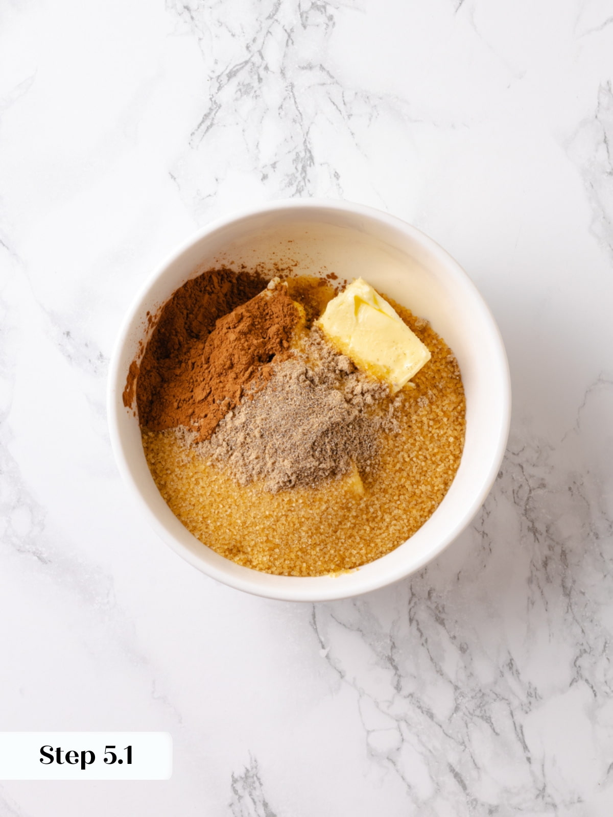 Small bowl holding butter, sugar, cinnamon, and cardamom ready to make the bun filling.