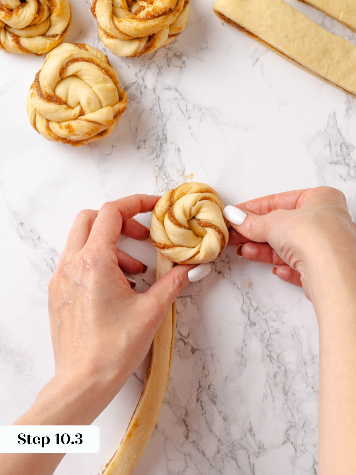 The right dough end tucked under the bun to hold its braided shape during baking.