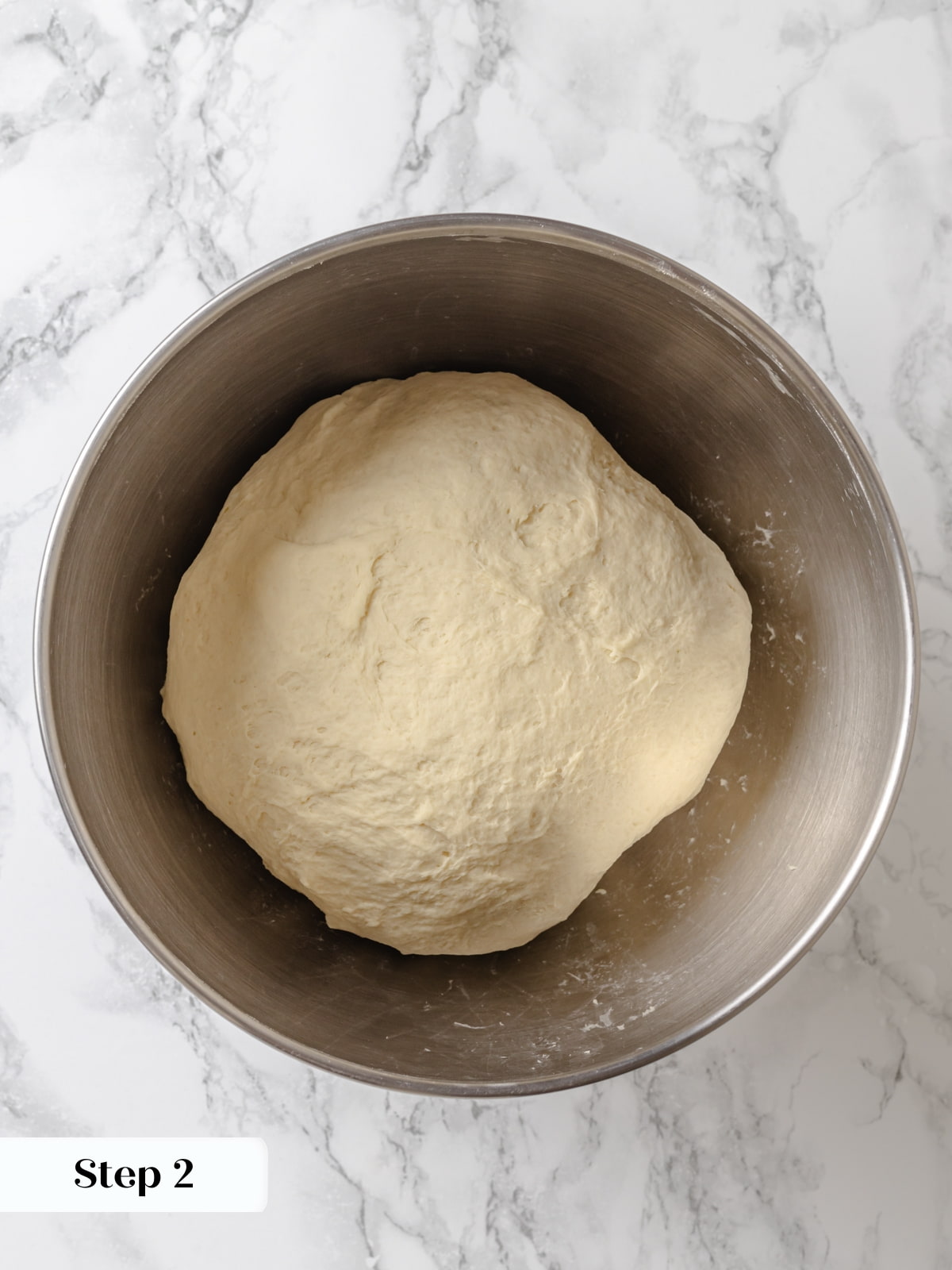 Bread dough shaped into a ball and worked by hand to build structure.
