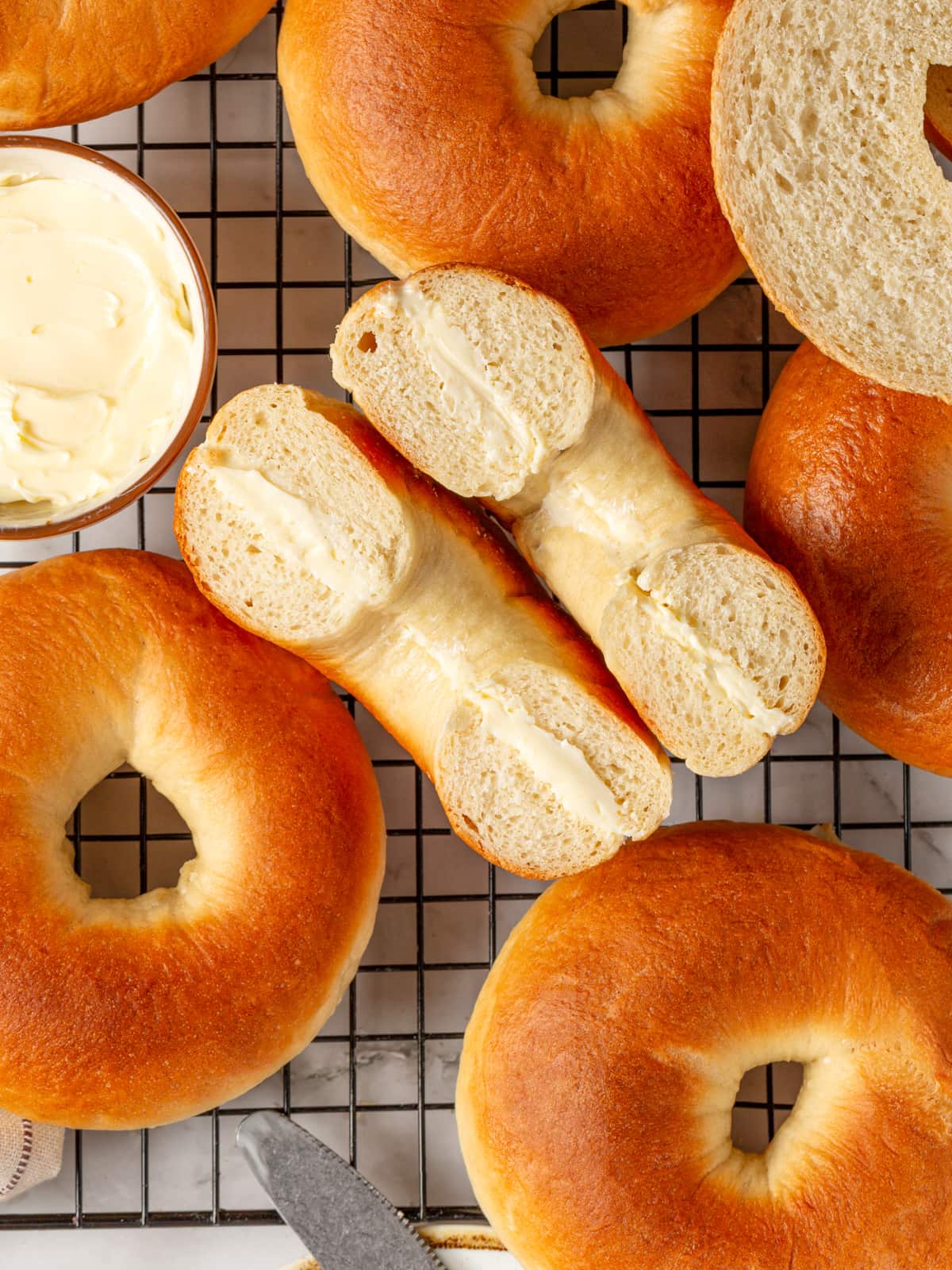 Bagel halves resting together with cream cheese inside, highlighting the soft center and crust.