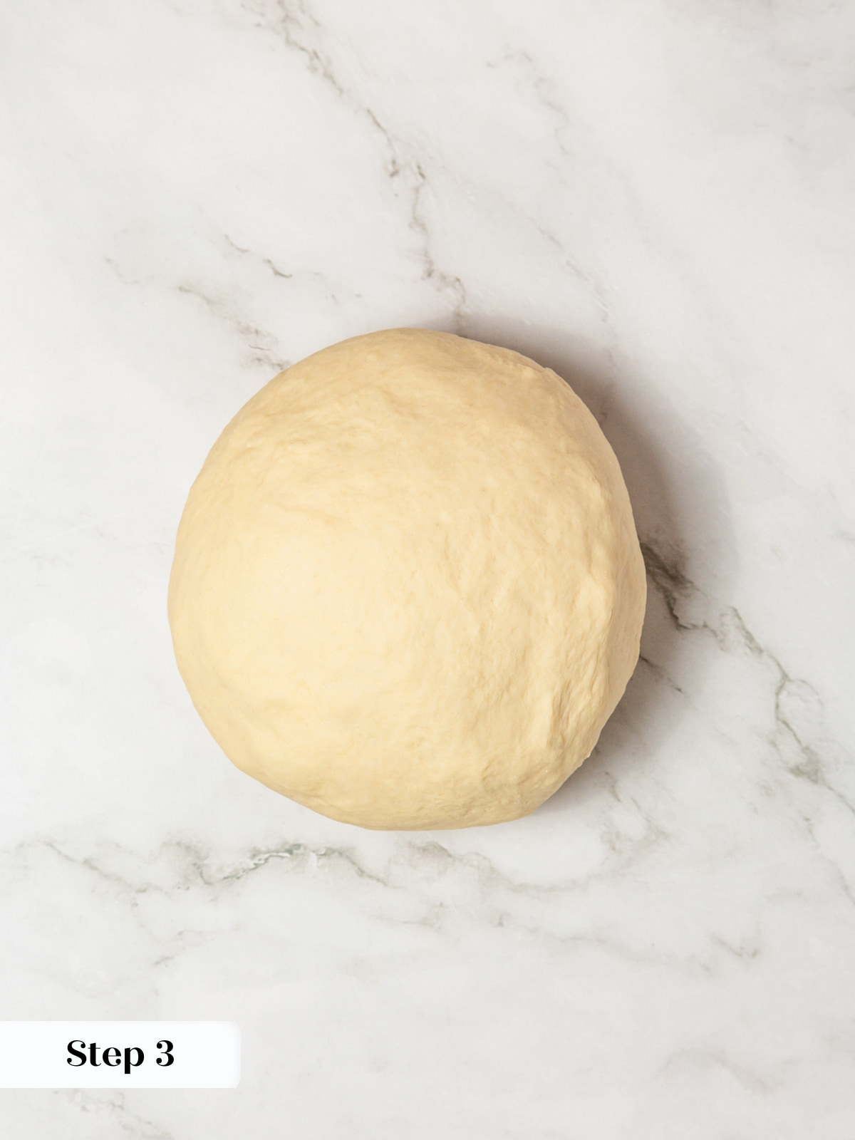 A smooth dough ball formed after kneading demonstrating readiness for shaping.