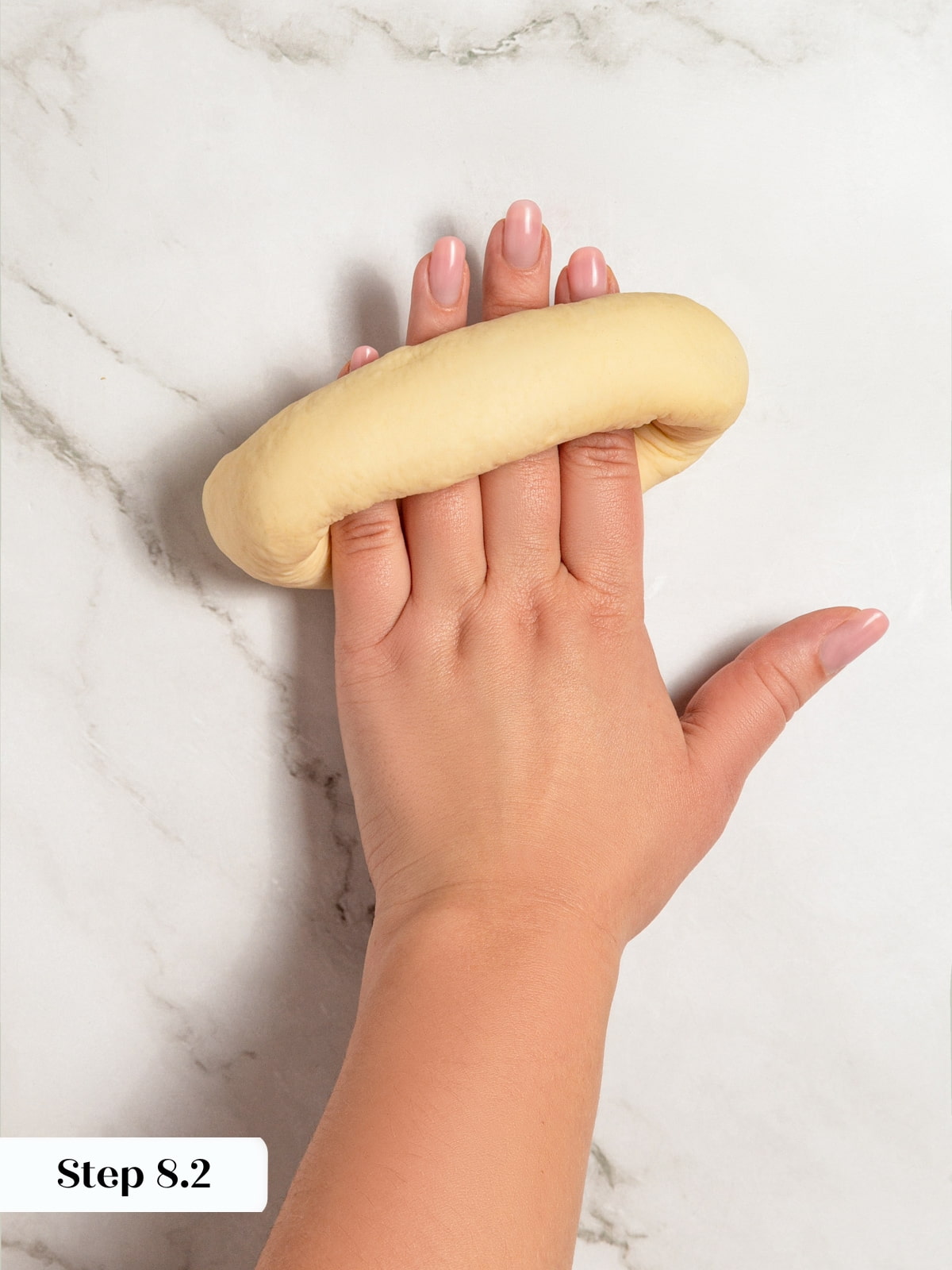 A dough rope being rolled gently to join the ends securely for shaping.