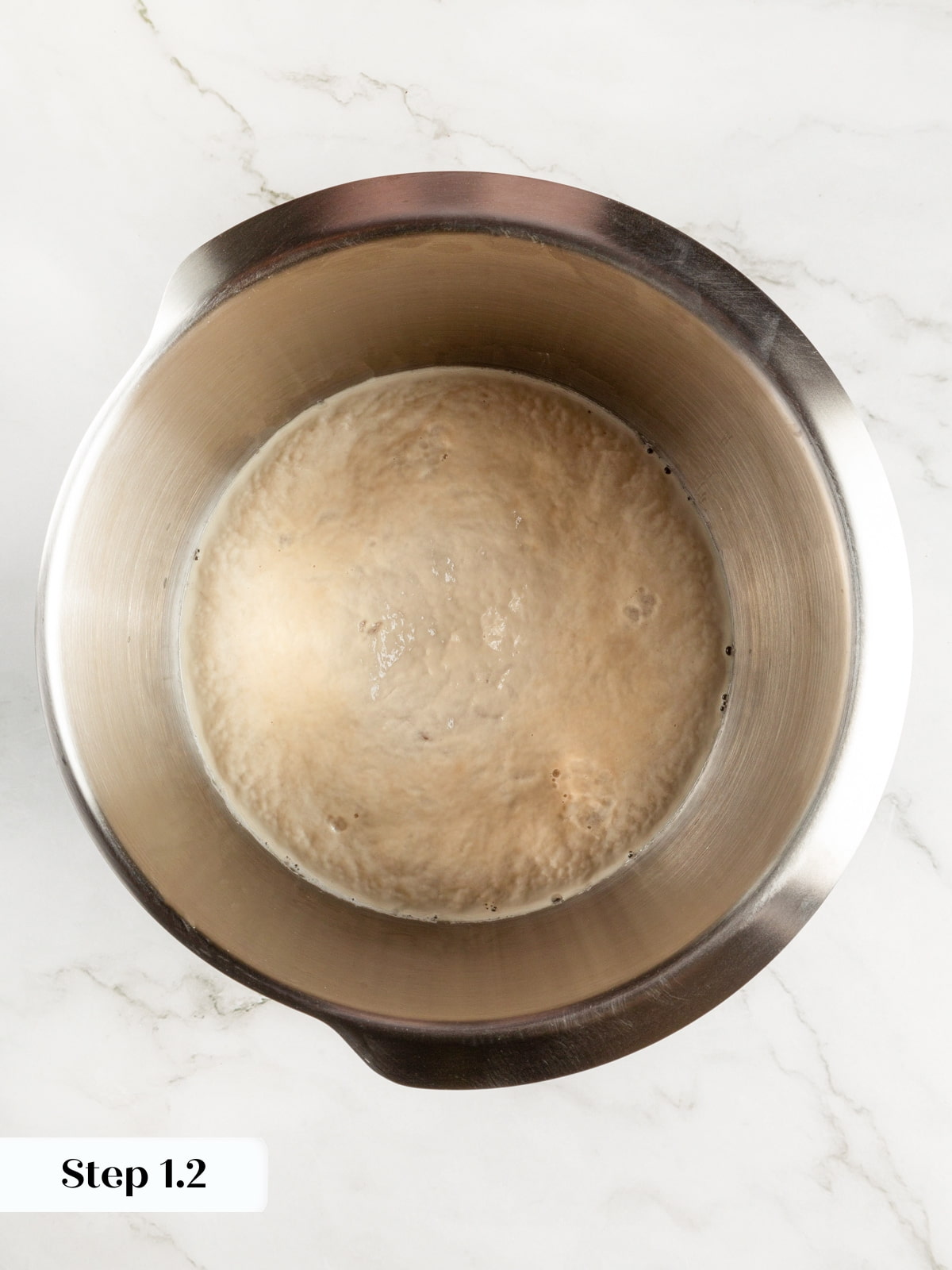 Foamy yeast mixture in a bowl showing proper activation before adding flour.