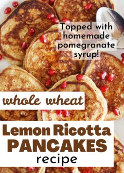 Golden brown lemon ricotta pancakes on a plate topped with pomegranate syrup and bright red pomegranate seeds.