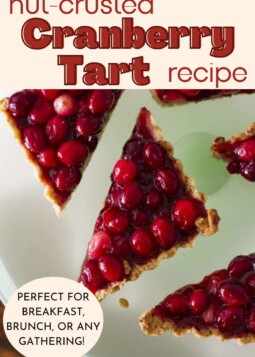Slices of brightly colored tart with fresh cranberries and walnut crust on a plate.