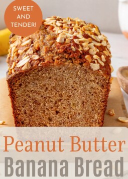 Peanut butter banana bread on a cutting board with visible chopped peanuts on top.