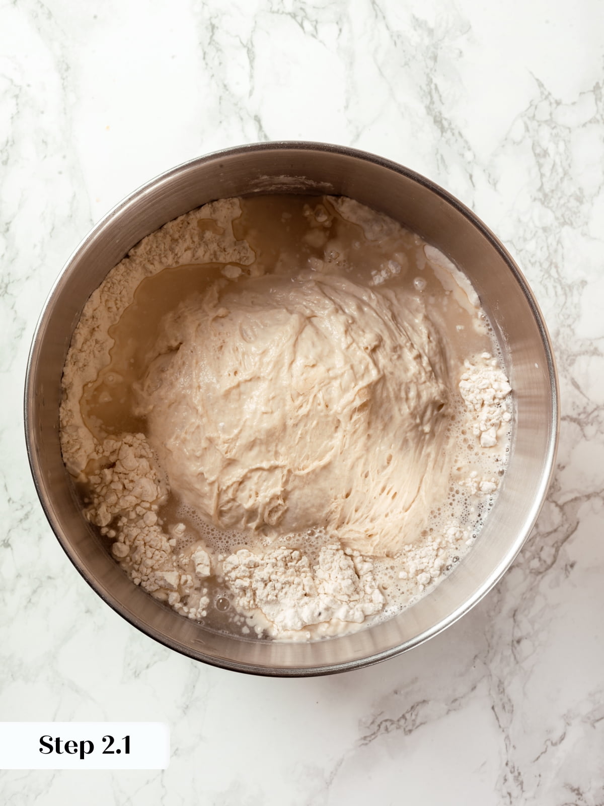 Biga, water, bread flour, and salt added together during sourdough mixing process.