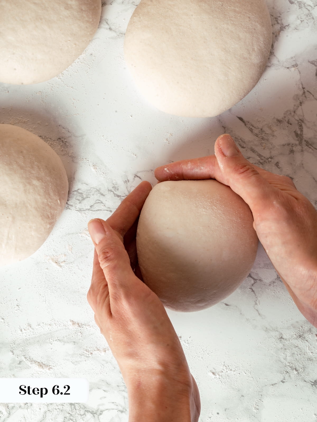 Hands shaping sourdough dough into a tight round boule for baking.