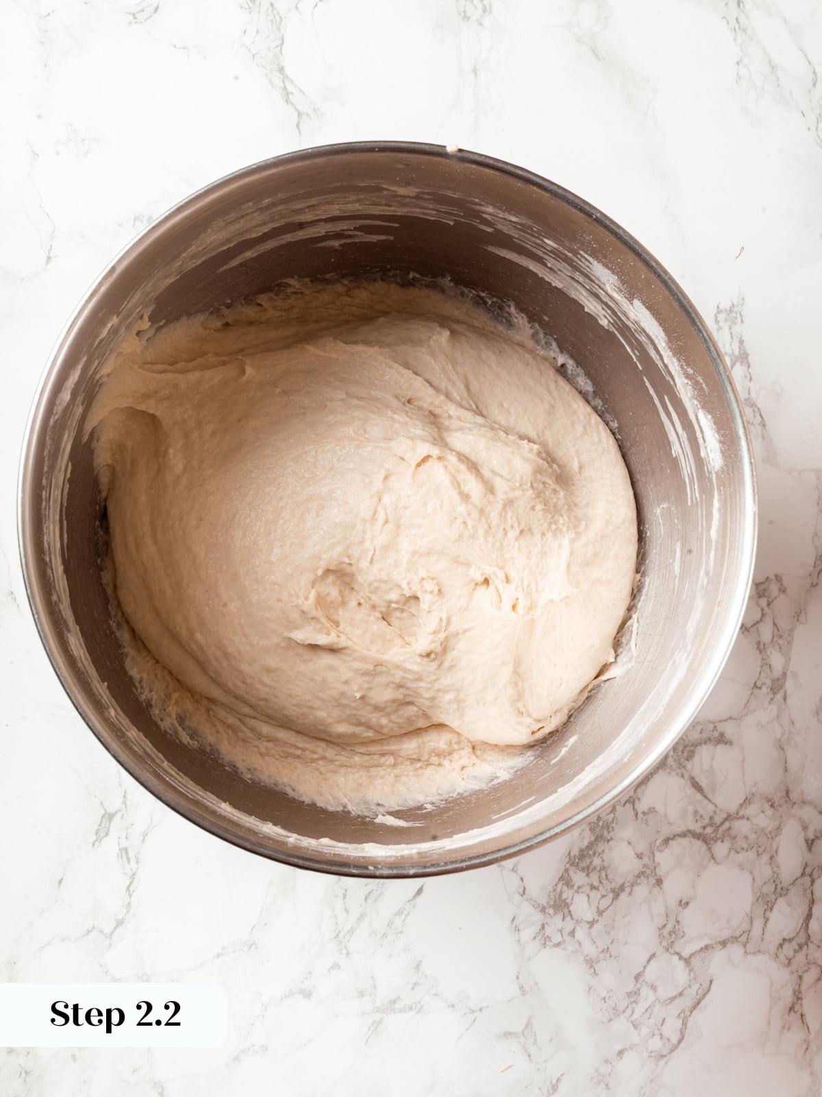 Stand mixer combining sourdough ingredients into smooth, elastic bread dough.