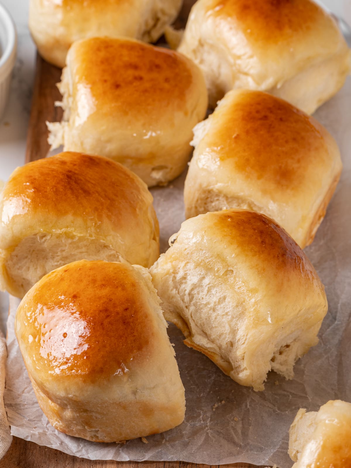 Freshly baked sourdough rolls showing their tender texture and lightly golden buttery surface.