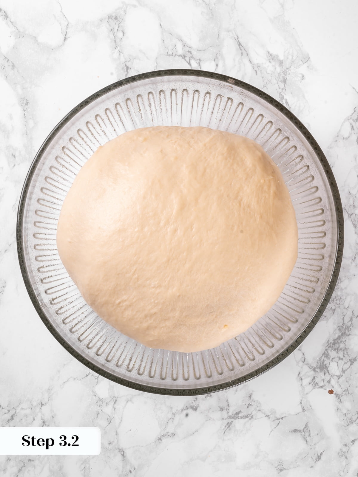 Dough that has doubled in size filling the bowl with a smooth lifted surface.
