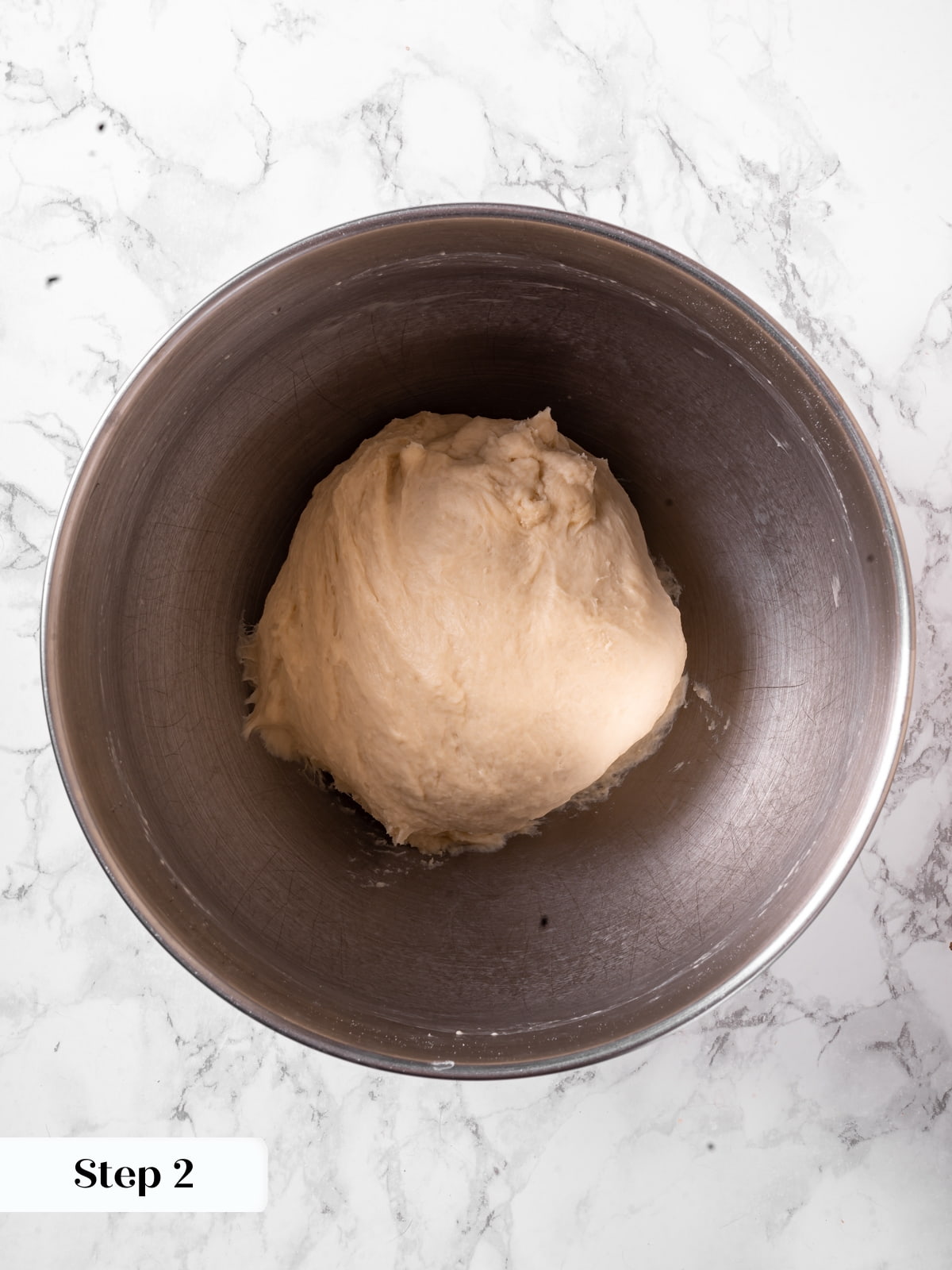Dough mixed into a smooth stretchy texture ready for rising inside the bowl.