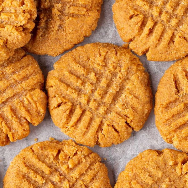 Peanut butter cookie surface showing traditional fork pressed crisscross marks.