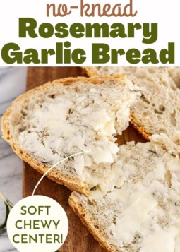 Slice of rosemary garlic artisan bread showing soft center with butter.