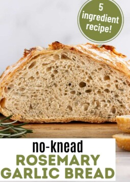 Loaf of rosemary garlic artisan bread cut open showing soft chewy center.