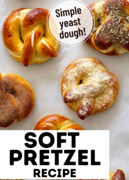 Variety of soft pretzels arranged on parchment with topped with salt, cinnamon sugar, garlic Parmesan, and za’atar sesame.