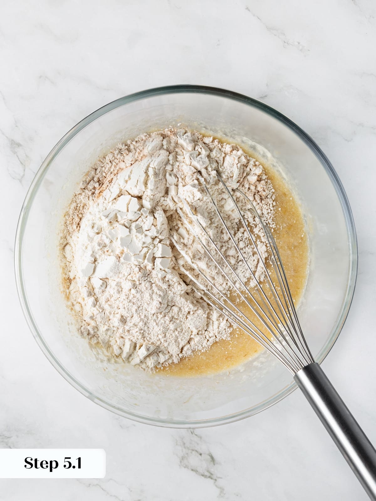 Flour mixture added to sourdough banana bread batter during mixing stage.