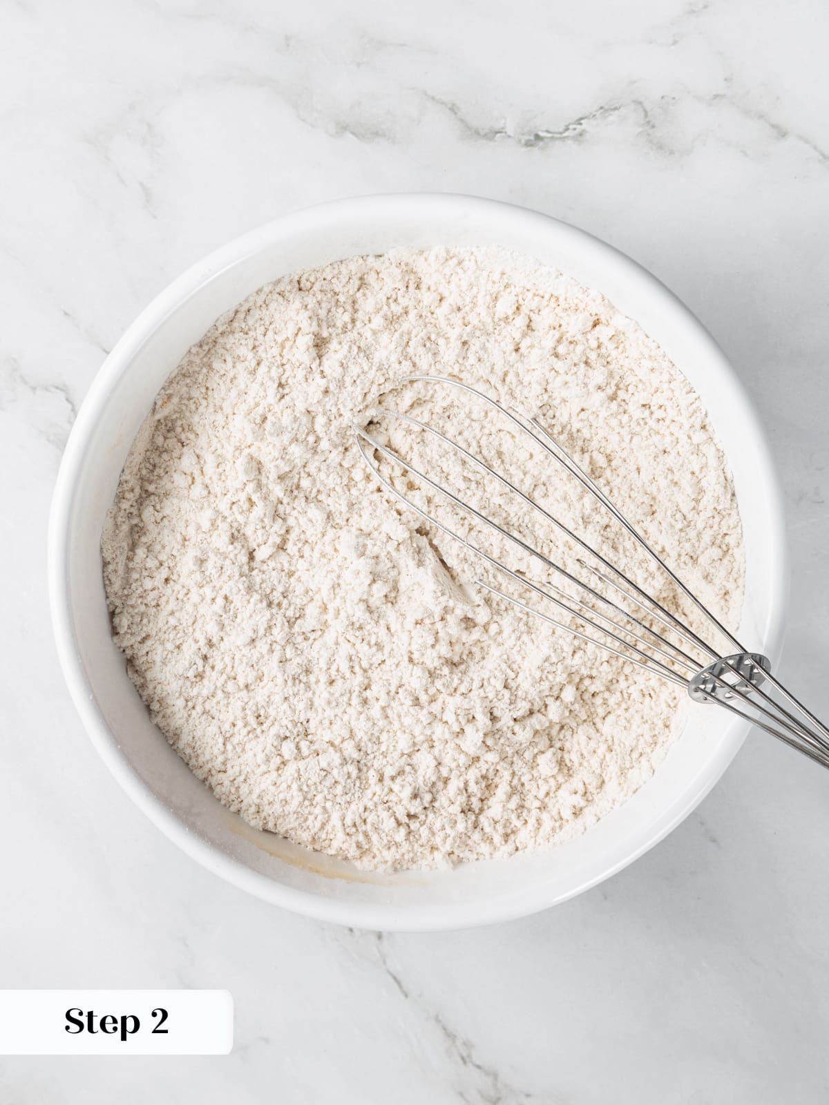Dry ingredients for banana bread whisked together in bowl.