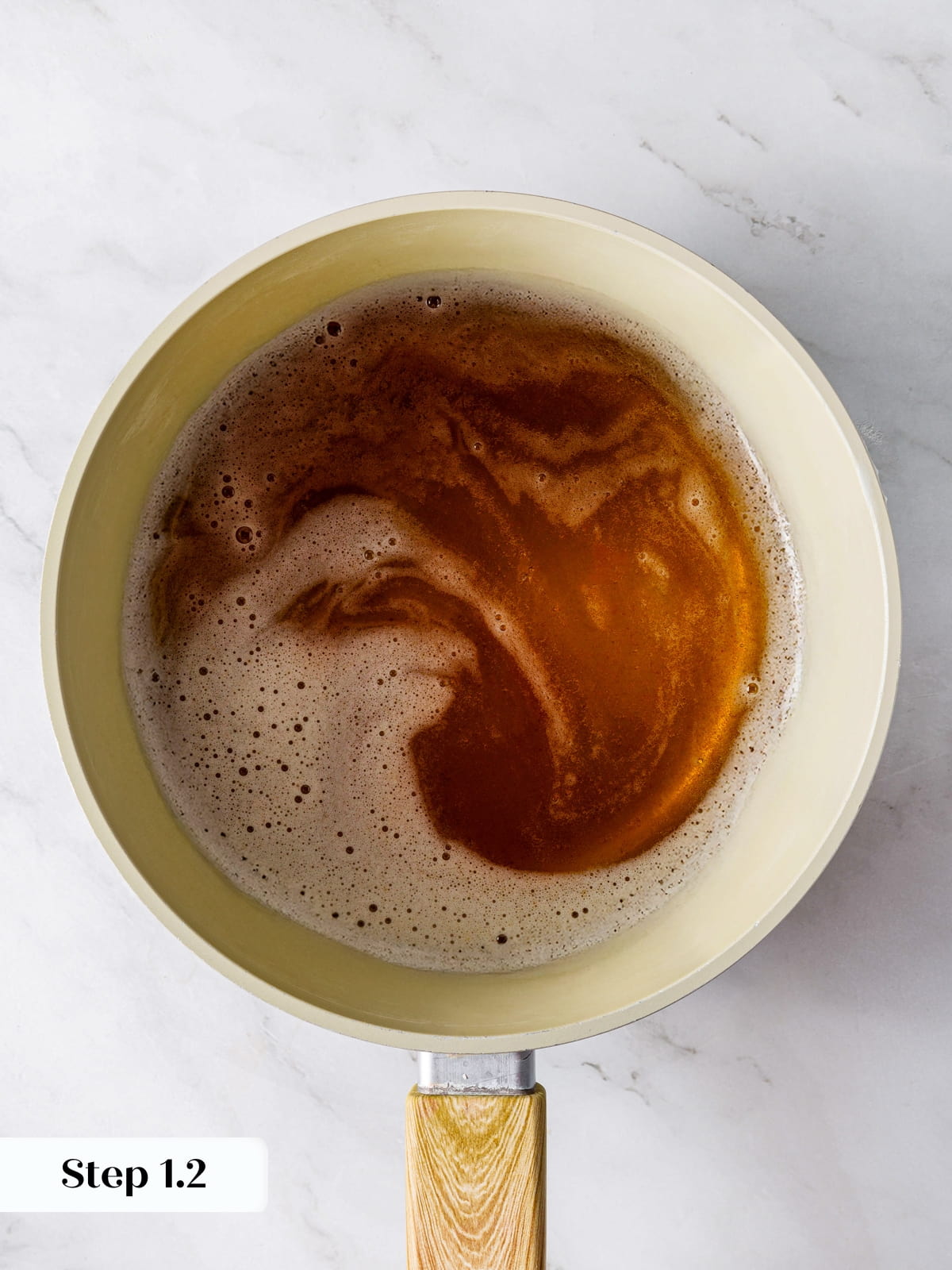 Saucepan of browned butter showing deep golden color and nutty bits.